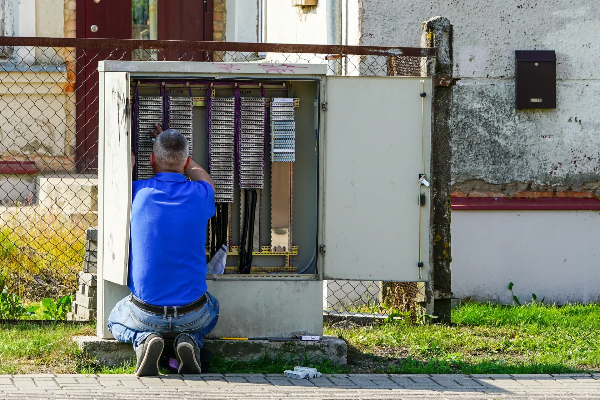Technician working in a copper telephone cross-connect cabinet